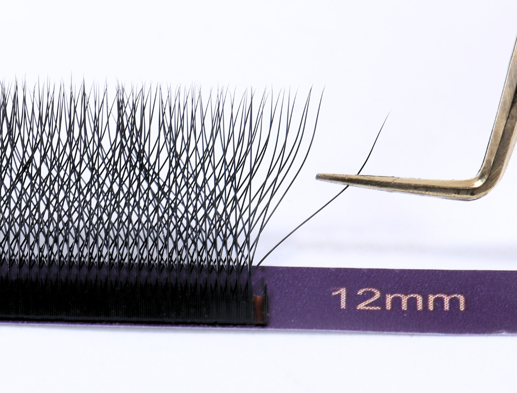 W 4D pre made volume lash fan picked up with tweezers showing stable fan structure